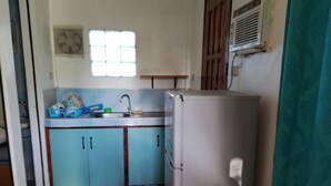 A compact kitchen with a sink, a refrigerator, and cabinets. - Siargao Hannah House (Surigao city)
