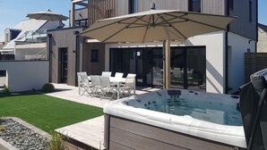 A modern outdoor patio with a hot tub, a covered seating area, and a wooden deck. - Air-conditioned house on the Rhuys peninsula with Jacuzzi (Saint-Gildas-de-Rhuys)