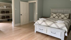 A bedroom with a bed, a wardrobe, and a door. - Newly built and fresh vacation home tucked in the woods of Mount Desert.  (Mount Desert)