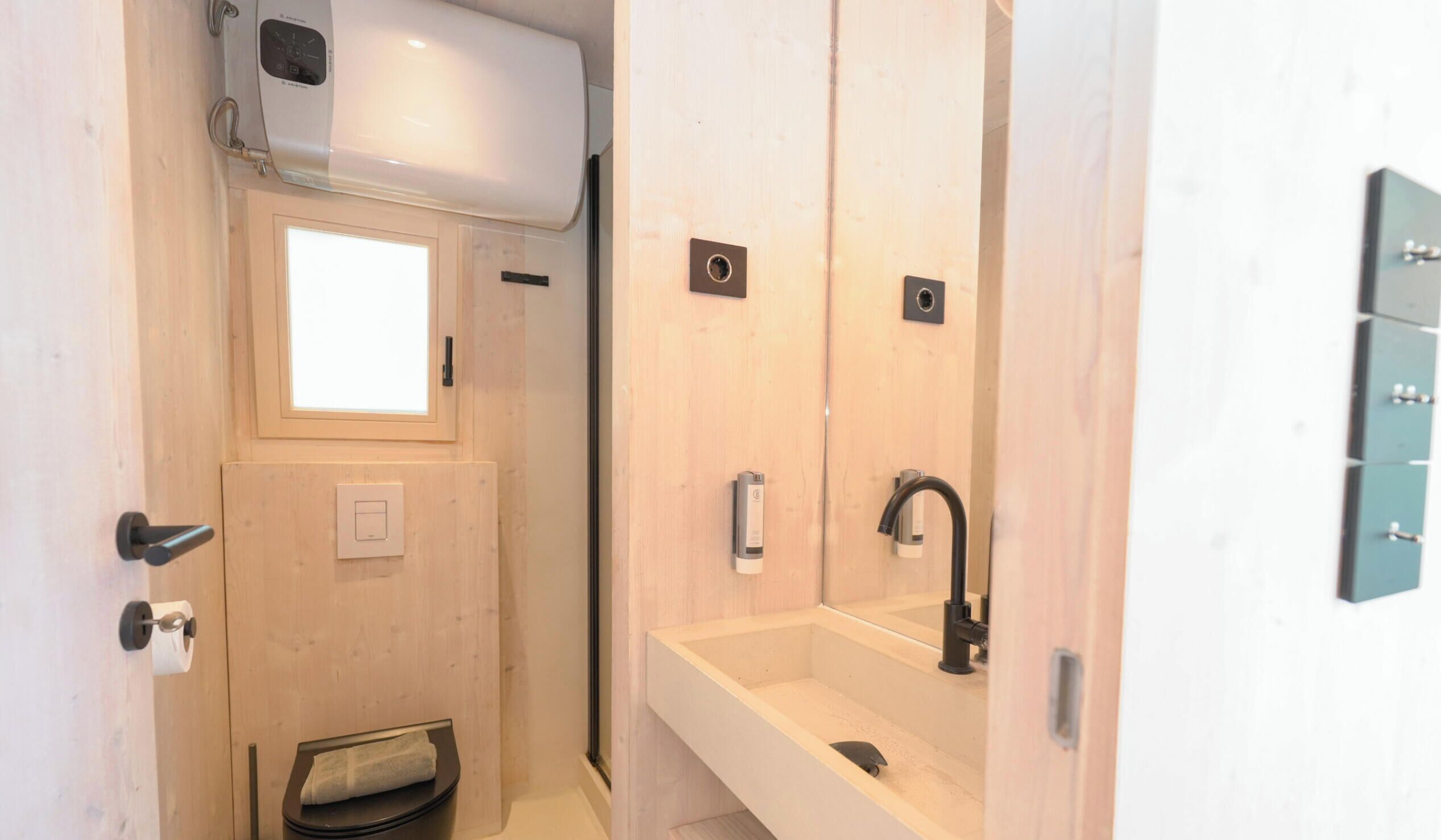 Une petite salle de bain comprenant des toilettes, un lavabo et une douche.