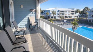 A balcony with a view of a swimming pool and adjacent buildings. - Sea Oats I-202. Pool View, Waterfront Access. 1K, 2Q, 1Q sofa bed. (Gulf Shores)
