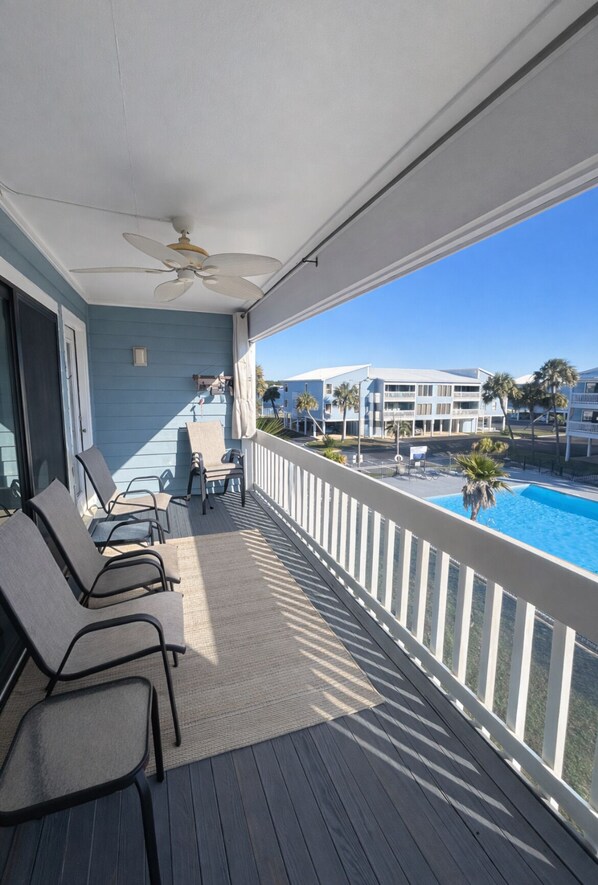 Un balcon donnant sur une piscine et les bâtiments adjacents.