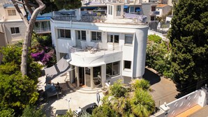 A two-story building with a balcony, outdoor seating, and a view of the surrounding neighborhood. - Villa in front of old port Golfe-Juan. Sea view, walk to beach, restaurants. AC! (Vallauris)