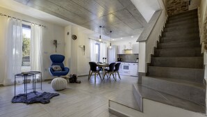 A modern interior with a staircase, dining area, and kitchen.