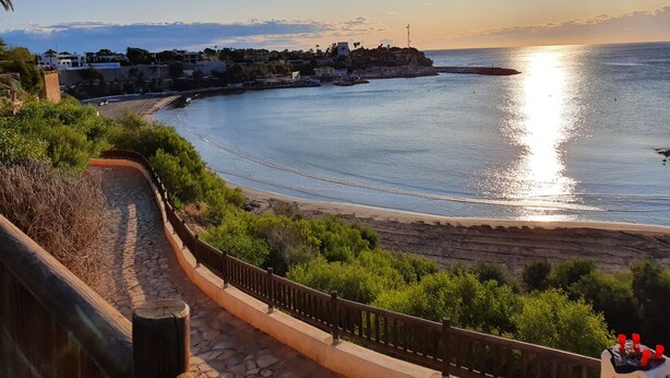 A coastal view with a stone pathway, a wooden railing, and a clear sky. - modern, newly renovated apartment in Cabo Roig, beach within walking distance (Orihuela)