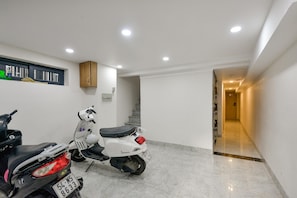 Stylish living space with a white scooter and a staircase leading to an upper level.