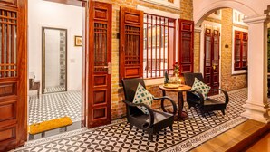 A traditional interior with wooden doors, patterned floor tiles, and a seating area with cushions. - Paddy Home (Cam Pha)