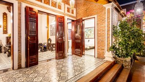 A traditional building with multiple wooden doors, a tiled entrance, and a brick exterior. - Paddy Home (Cam Pha)