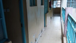 A corridor with tiled floors and blue-framed windows. - Kwiremia Hotel (Embu)