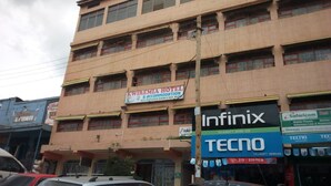 A hotel with multiple floors, balconies, and various signs including 'KWIREMIA HOTEL' and 'TECNO'. - Kwiremia Hotel (Embu)