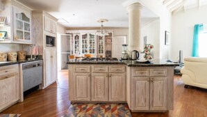 Una cocina amplia con armarios de madera, una isla central y un ventanal grande.