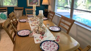 Une table à manger dressée avec des assiettes, des verres et un centre de table.