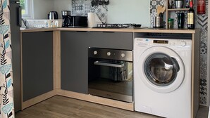A compact kitchen with a built-in oven, microwave, and washing machine. - Normandy: nature, history and comfort in a mobile home (Litteau)