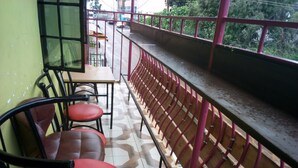 Un balcón con suelo de baldosas, una mesa y sillas.