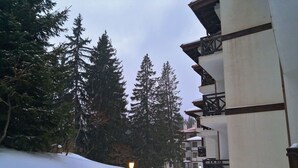 A snow-covered path leading to a building with balconies and a snow-covered roof. - Apartment for rent in the Rhodope mountain suitable for all year long (Smolyan)