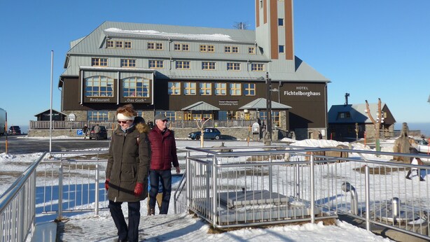 A hotel with a prominent tower and multiple windows. - Cable car, lift, slopes, ski schools are within walking distance. Family friendly (Kurort Oberwiesenthal)