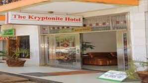 The Kryptonite Hotel with a visible entrance, a signboard, and a small outdoor seating area.