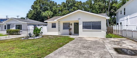 A single-story house with a front porch, a small front yard, and a garage.