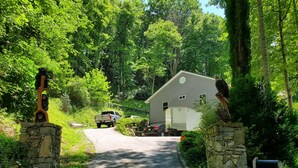 A driveway leading to a house with a stone mailbox and a mailbox post. - Maggie Valley Mountain View Suite & Spa (Maggie Valley)