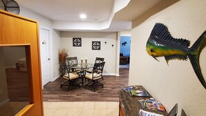 A dining area with a round table and chairs, a fish wall art, and a magazine rack. - Maggie Valley Mountain View Suite & Spa (Maggie Valley)