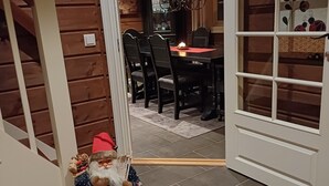 Un coin repas accueillant avec une table et des chaises en bois, un globe décoratif accroché au mur et un petit panier pour chien avec un jouet.