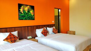 Een hotelkamer met twee bedden, oranje wanden, een houten hoofdeinde en een bloemen schilderij.