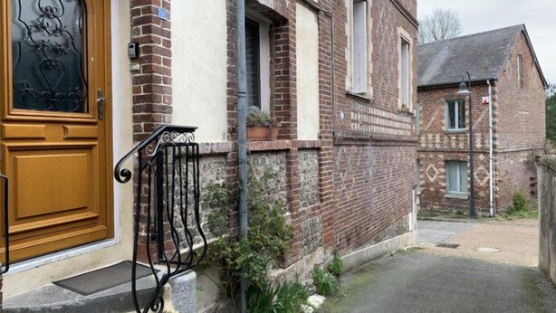 A traditional brick building with a wooden door and a metal gate.