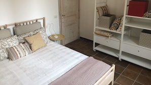Quarto com cama, guarda-roupa e uma pequena mesa.