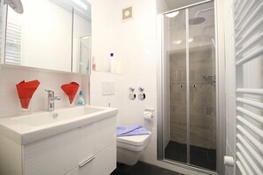 A modern bathroom with a white sink, mirror, and glass shower enclosure. - Farchanter Alm (Farchant)