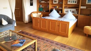 A cozy room with a bed, a sofa, a coffee table, and a bookshelf. - Marie-Anne (Garmisch-Partenkirchen)