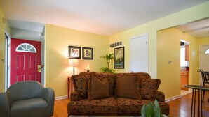 A living room with a sofa, a chair, a coffee table, and a door. - SWEET! near Downtown PWR & LIGHT Westport KUMC (Kansas City)
