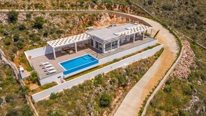 Une villa moderne dotée d’une piscine, d’un espace salon extérieur et d’une terrasse couverte.