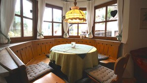 A cozy corner seating area with a round table, benches, and a hanging lamp. - Chalet Adriana (Garmisch-Partenkirchen)