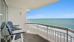 A balcony with two Adirondack chairs, a 'NO SMOKING' sign, and a view of the ocean. - 1011 Waters Edge Resort 2 Bedroom Condo by RedAwning (Murrells Inlet)