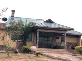 Una casa con techo de metal, fachada de piedra y un pequeño porche frontal con escalones que conducen a la entrada.