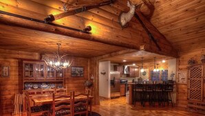 A log cabin interior with a dining area, kitchen, and bar. - Charming Adirondack Log Cabin PRIVATE BEACH ACCESS to Mirror Lake (Lake Placid)