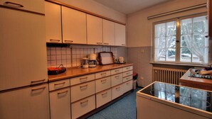 Eine Küche mit weißen Schränken, einer Arbeitsplatte, einem Fenster und einem Herd.