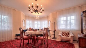 Ein Esszimmer mit einem runden Tisch, Stühlen und einer Deckenleuchte.