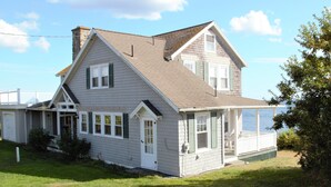 A two-story house with a porch, a chimney, and a view of the water. - Ocean Front at Fortunes Rocks (Fortunes Rocks)