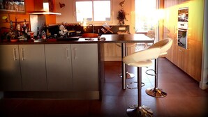 A modern kitchen with a central island, pendant lights, and bar stools. - NEW Villa with JACUZZI, near St Cyprien beach (LECCI)
