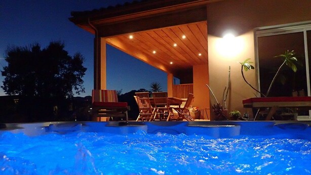 A swimming pool with a wooden deck and lounge chairs, surrounded by a building with a covered patio area. - NEW Villa with JACUZZI, near St Cyprien beach (LECCI)