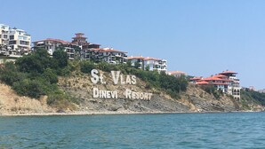 A coastal view of St. Vlas Dinev Resort with multiple buildings on a hillside overlooking the sea. - 3 Bed Apt, Garden of Eden, St Vlas, Bulgaria (Sveti Vlas)
