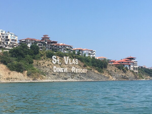 A coastal view of St. Vlas Dinev Resort with multiple buildings on a hillside overlooking the sea. - 3 Bed Apt, Garden of Eden, St Vlas, Bulgaria (Sveti Vlas)