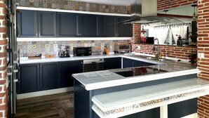 Una cocina moderna con armarios oscuros, salpicadero de azulejos y una isla central.