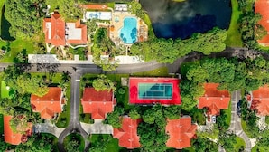 An aerial view of a residential area with houses, a swimming pool, and a tennis court. - Sandy Shores Villa near Sieta Key and other beaches (Sarasota)