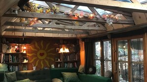 Ein gemütliches Zimmer mit einem grünen Sofa, einem Holztisch und einem Bücherregal.
