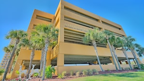 A modern building with a sign reading "Treasure Island 5004 Thomas Drive Resort Condominium."