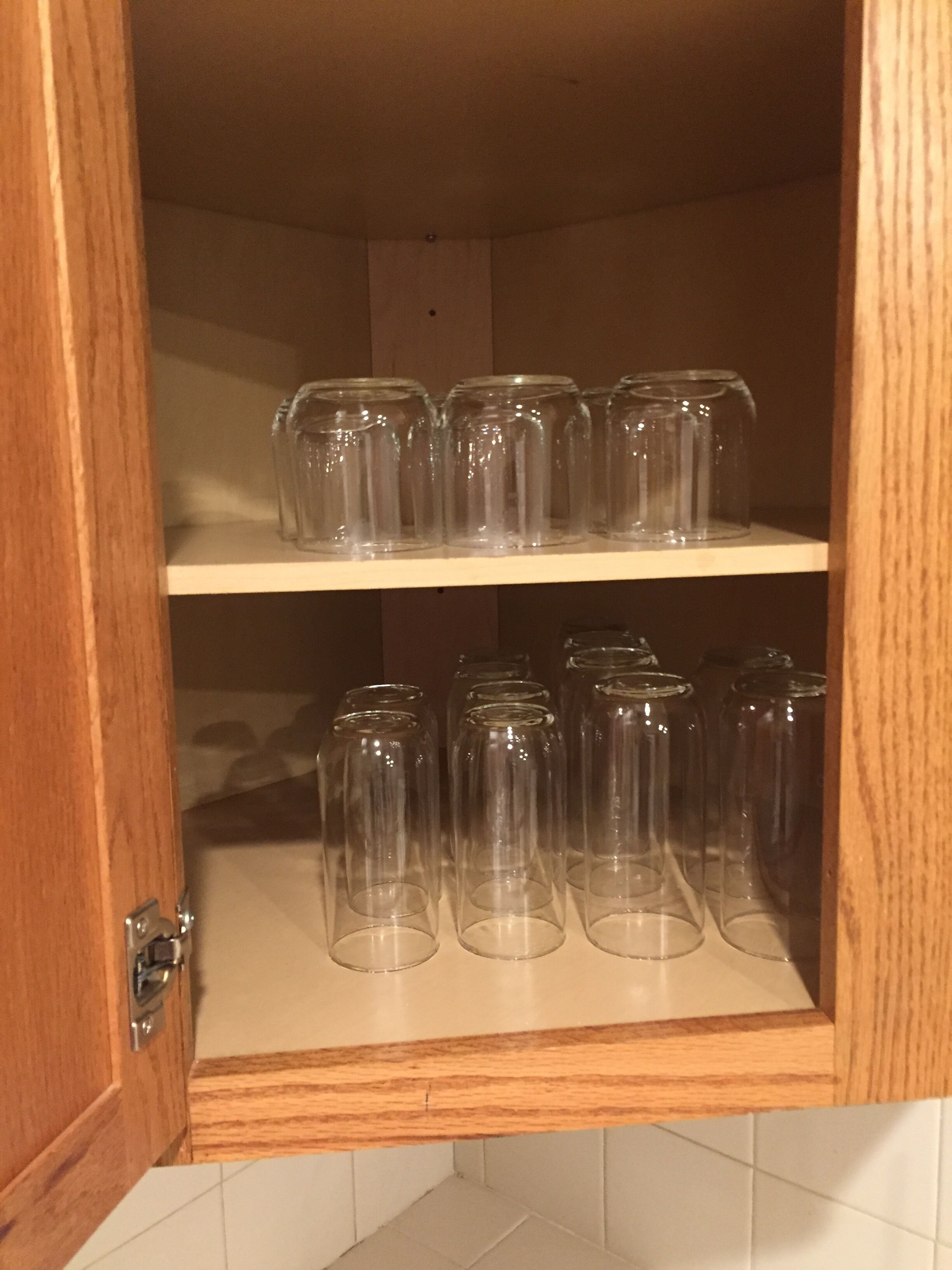 Un mueble de madera con dos estantes, cada uno con varios frascos de vidrio transparentes.