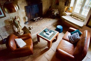 Una sala de estar acogedora con sofás de cuero, una pequeña mesa de centro de madera y una chimenea.
