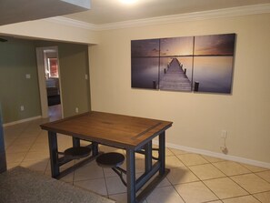 Relax in a serene space with a wooden table, black stools, and a stunning wall art.